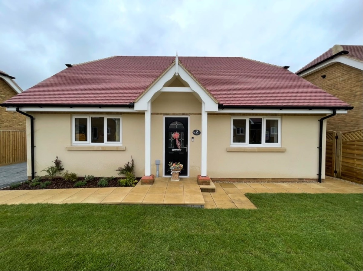 Rendered bungalow front elevation with porch and lawn